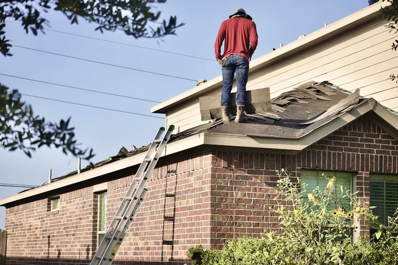 Professional roofer working on a residential roof in Mendon